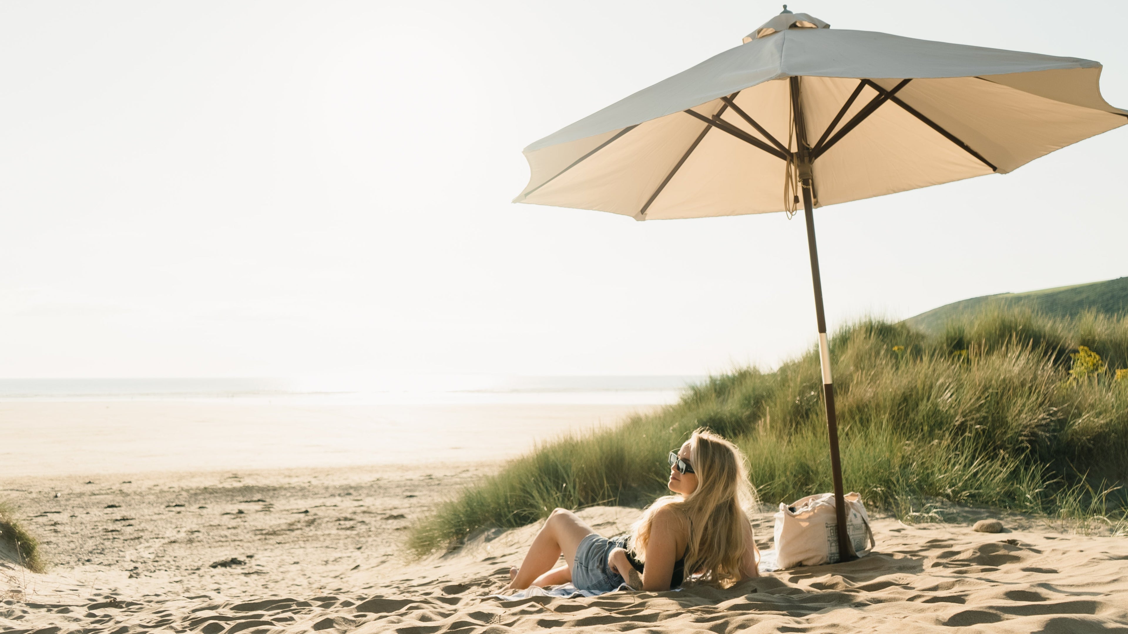 Woman lying on a beach under an umbrella