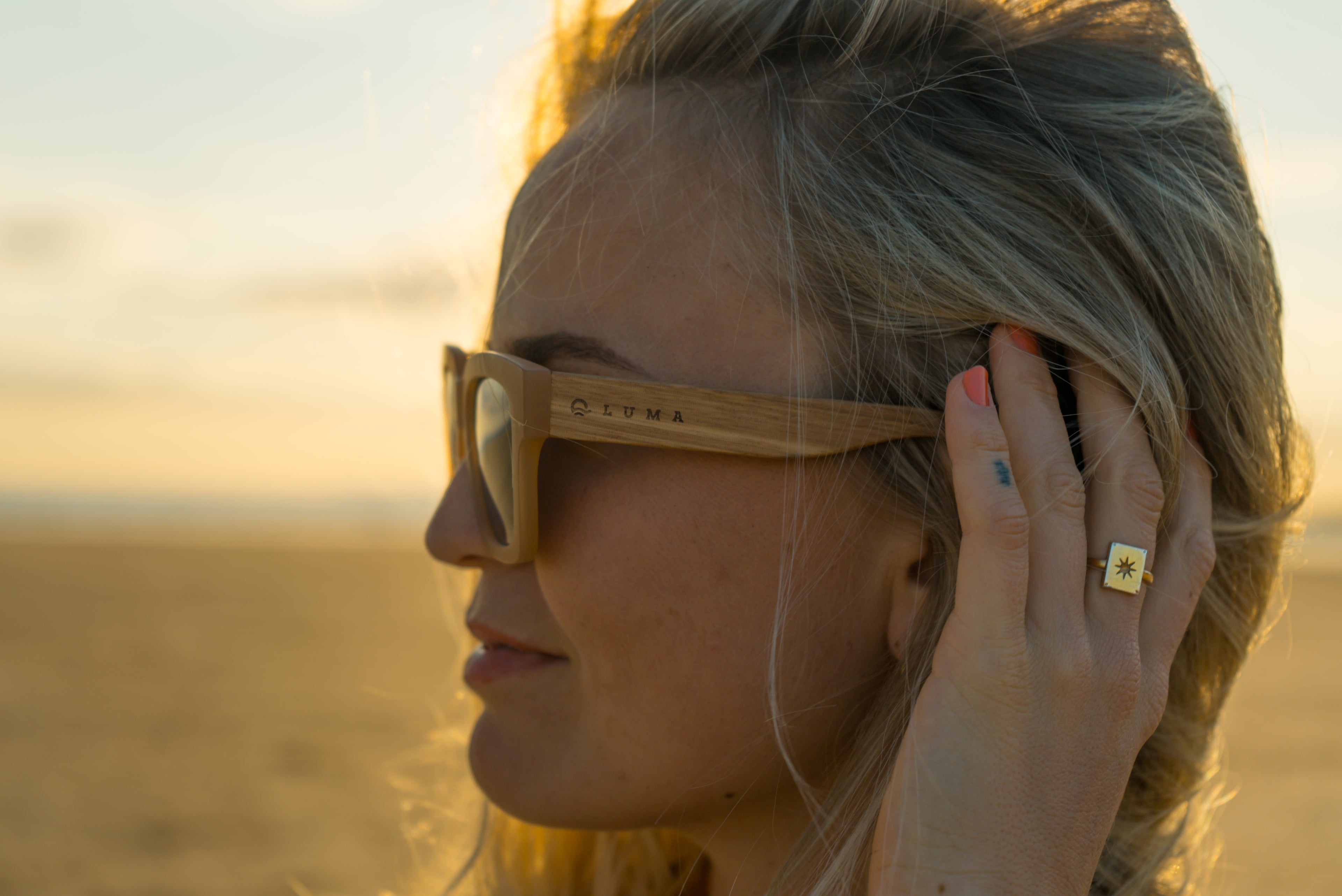 Side view of young woman at beach wearing Luma eyewear sunglasses