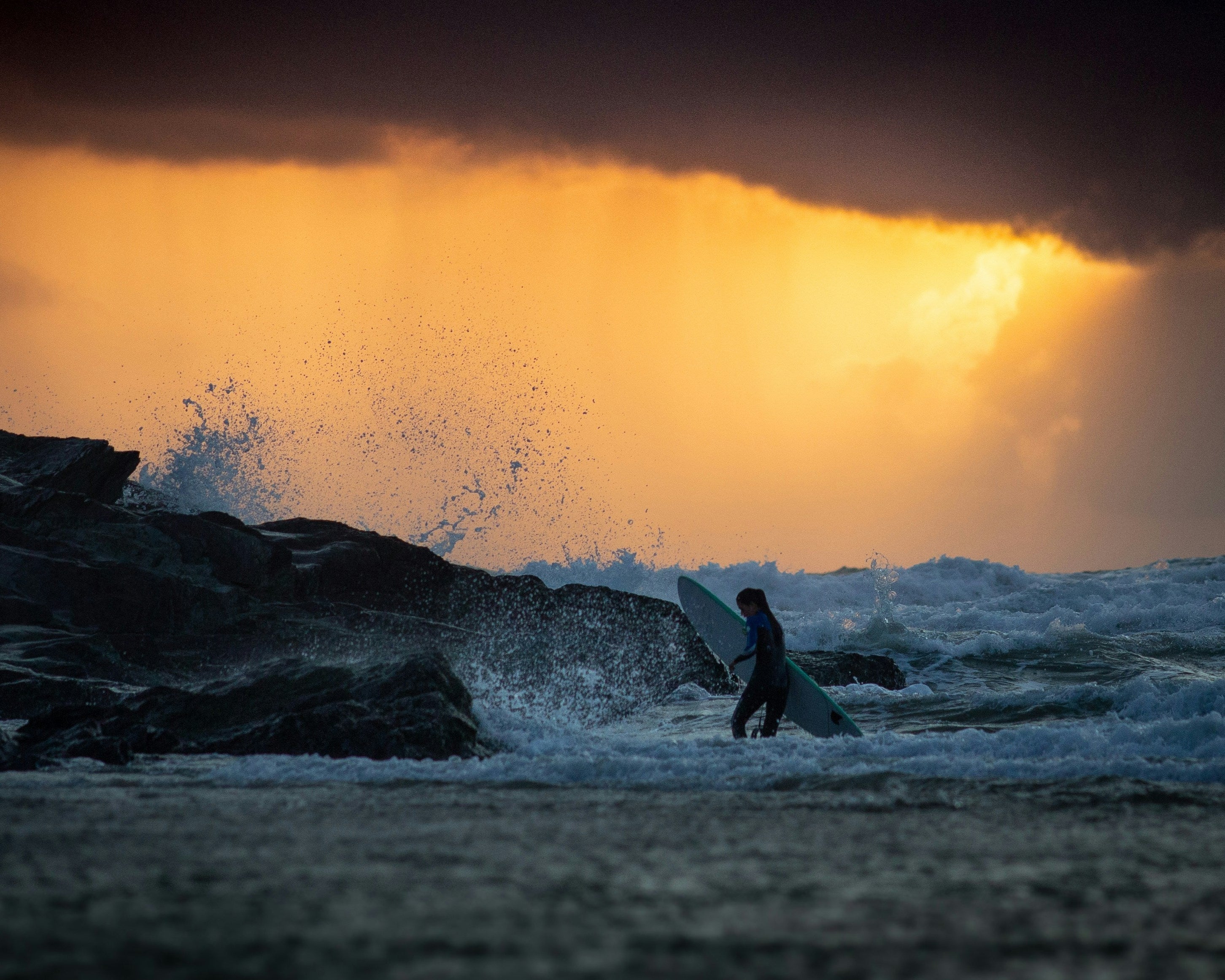 Surfer in the waves at Polzeath beach cornwall