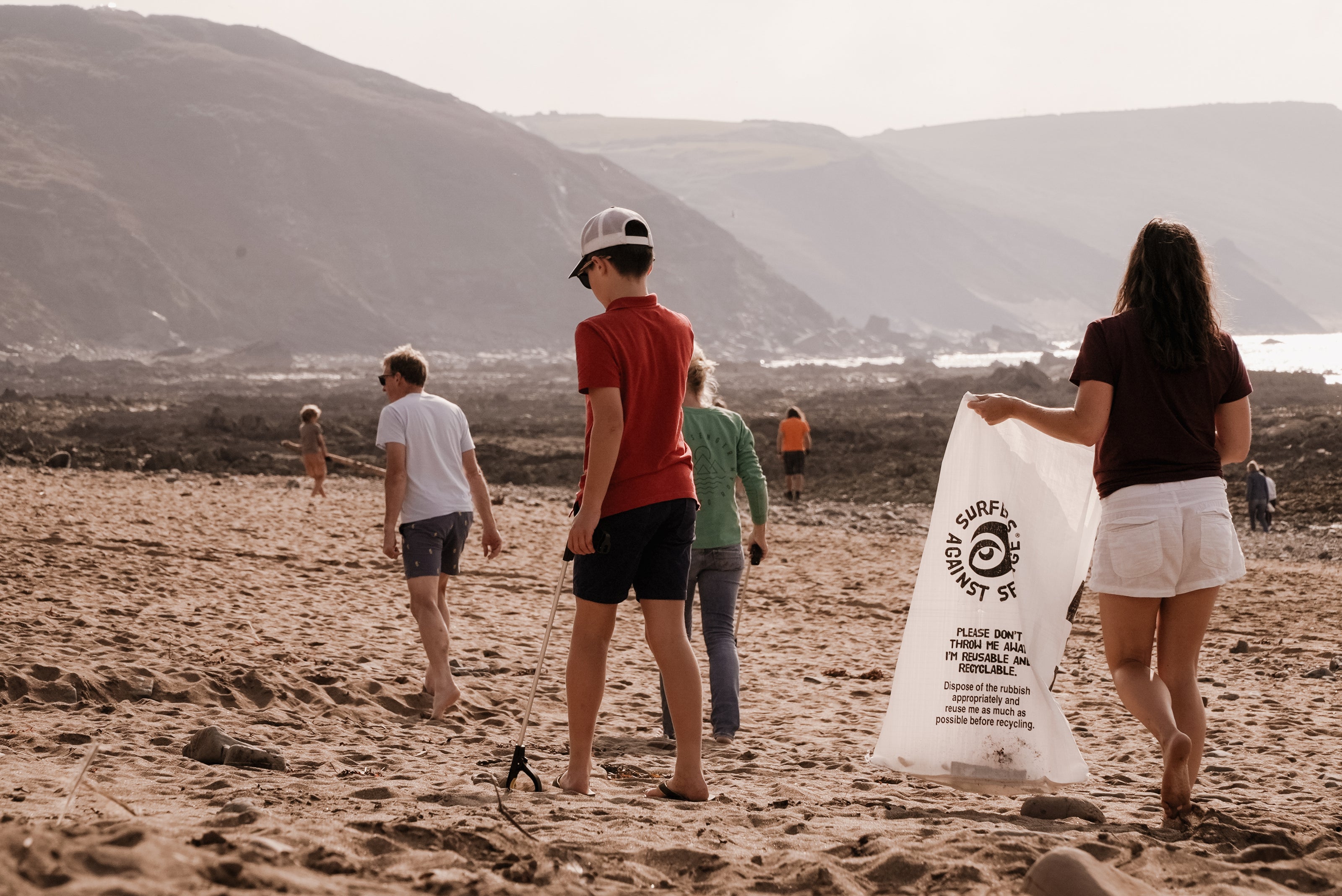 People walking on beach participating in Cornwall beach clean