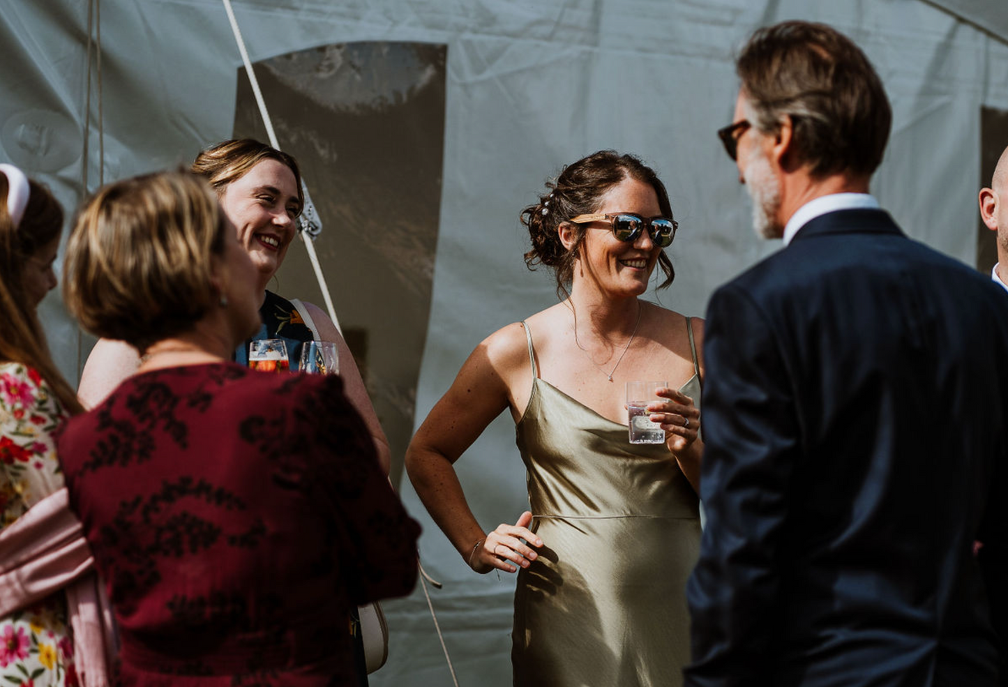 Bridesmaid talking to wedding guests wearing sunglasses