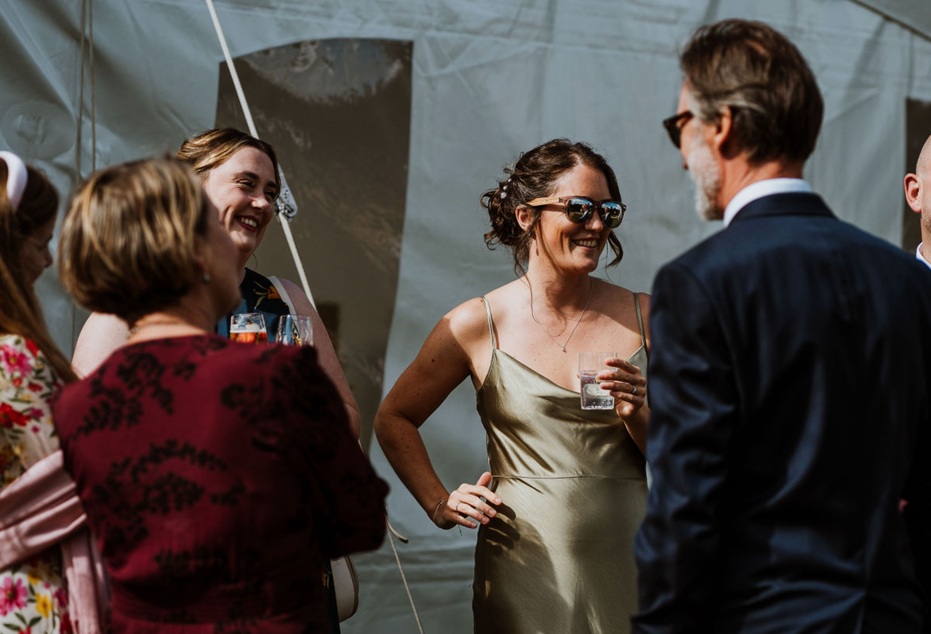 Bridesmaid talking to wedding guests wearing sunglasses