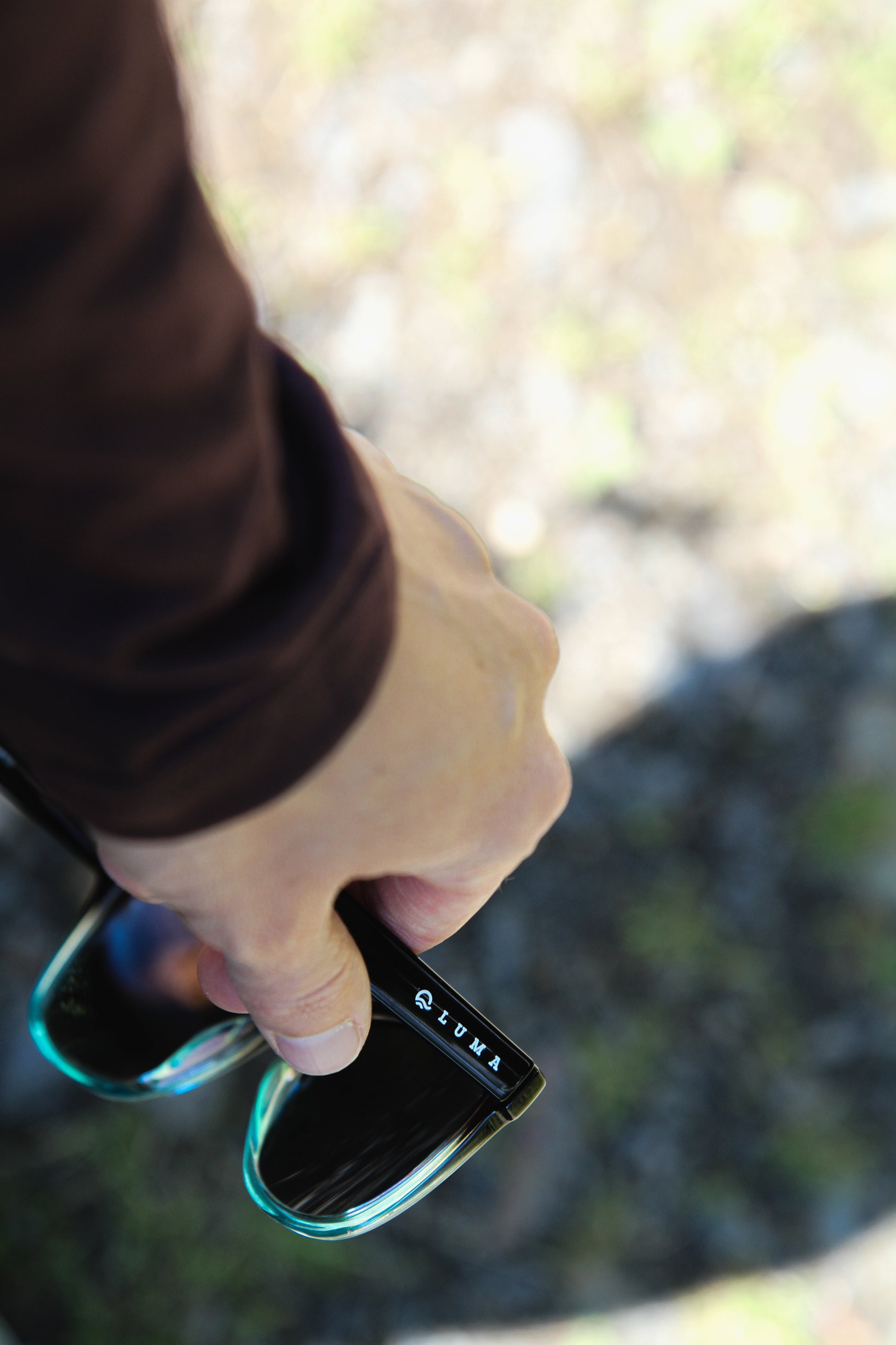 Close up view of hand holding sunglasses