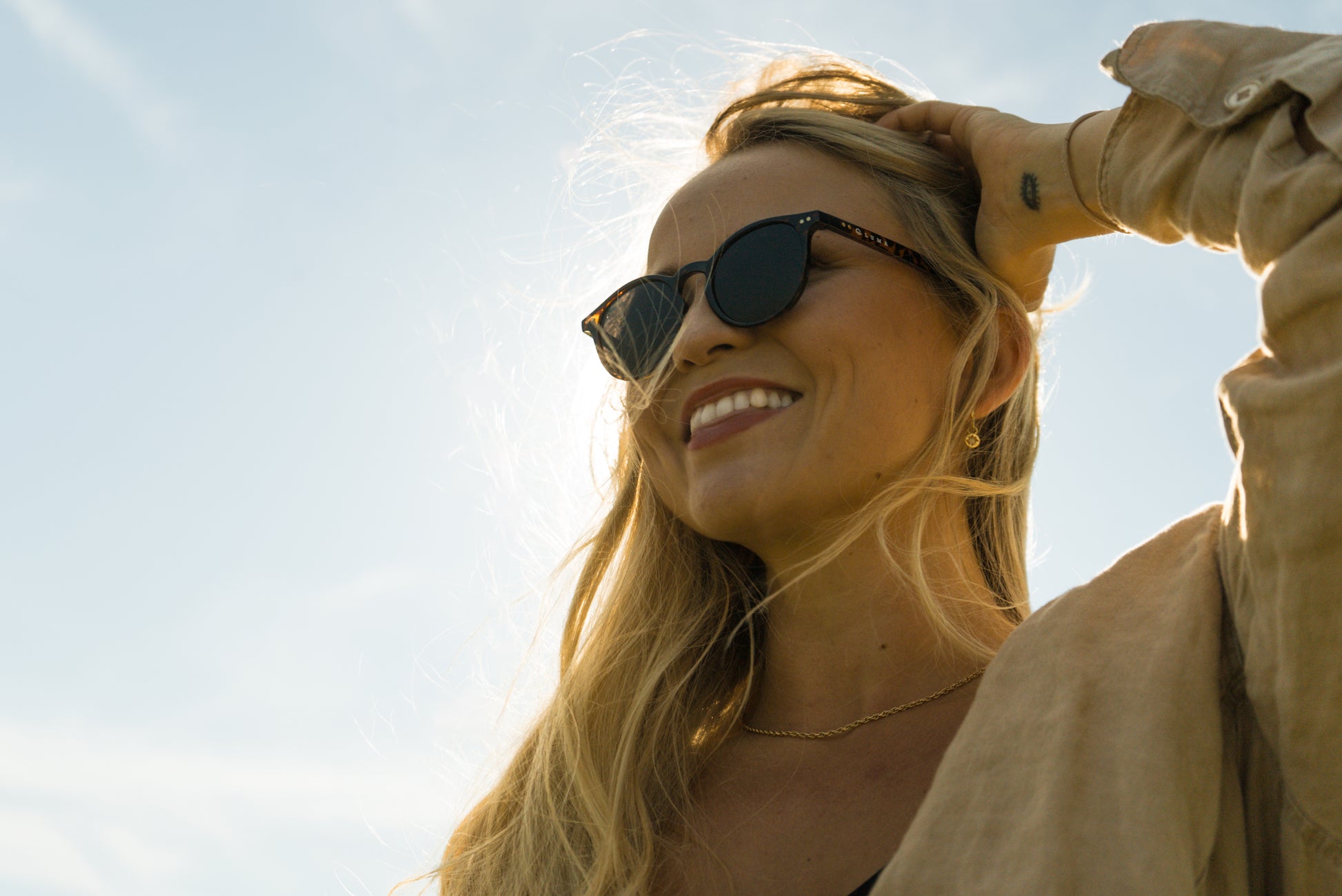 Smiling young women wearing sustainable sunglasses 