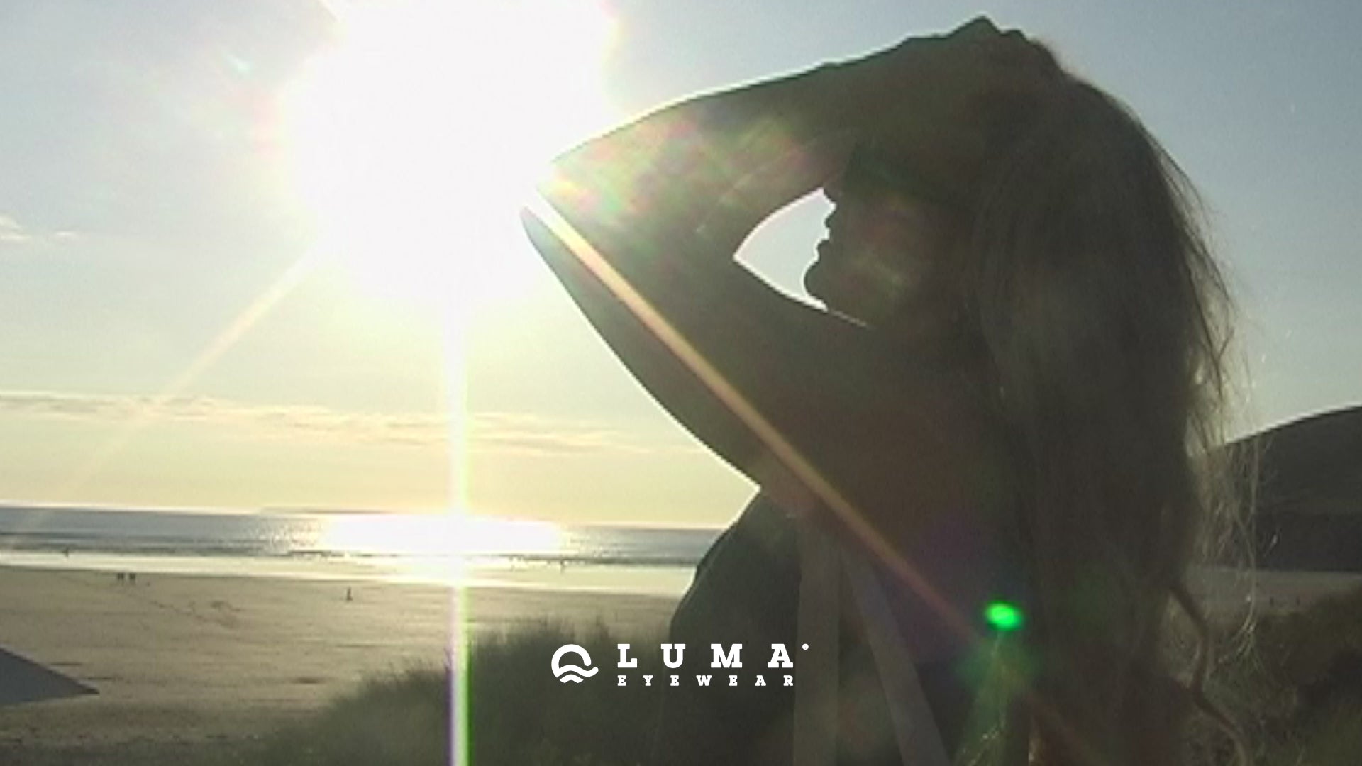 Model on beach at sunset wearing sustainable sunglasses